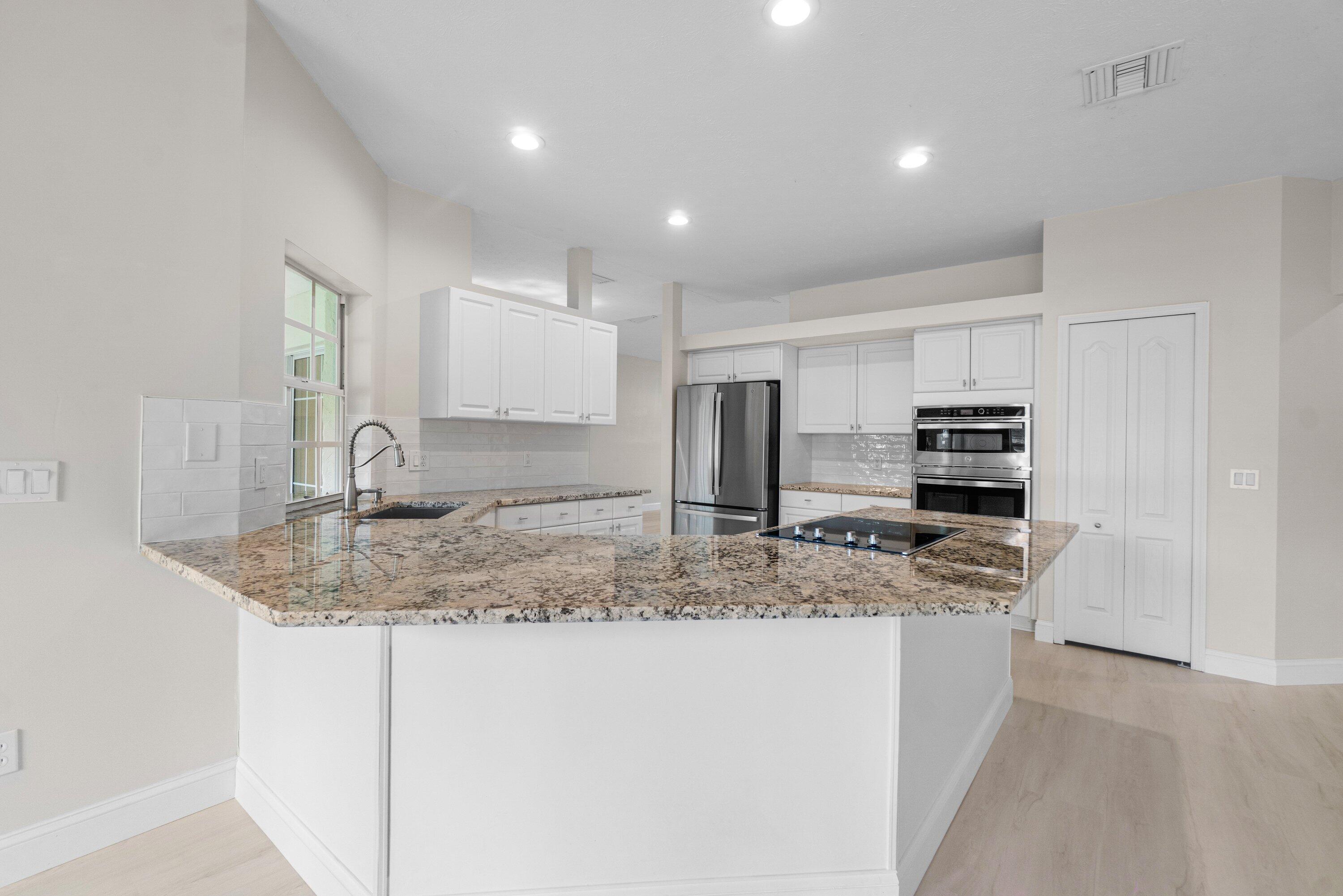 6807 Shelley Terrace Port St. Lucie, FL 34952 - Photo 12 of 34 a kitchen with stainless steel appliances granite countertop a sink and a granite counter tops
