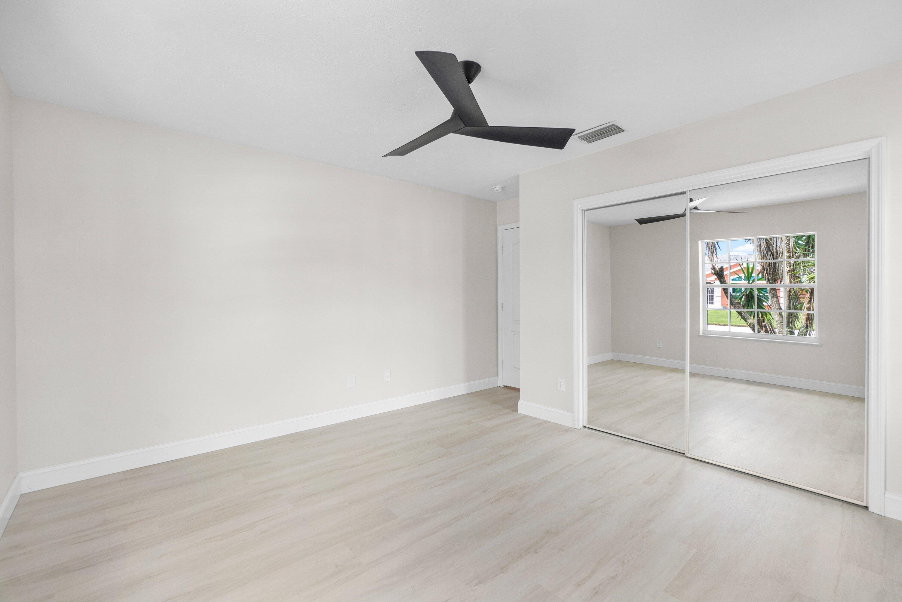 6807 Shelley Terrace Port St. Lucie, FL 34952 - Photo 19 of 34 an empty room with wooden floor and windows