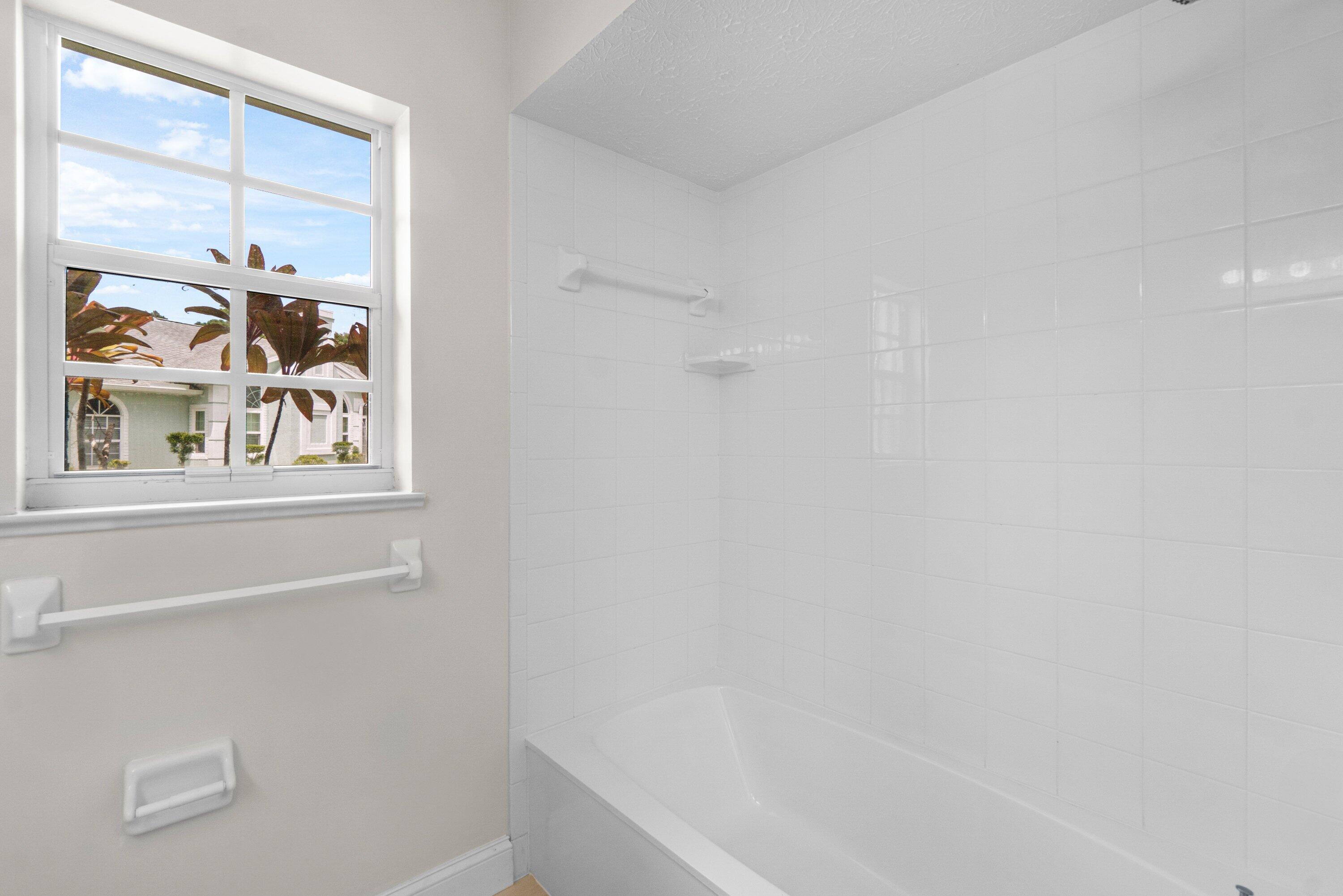 6807 Shelley Terrace Port St. Lucie, FL 34952 - Photo 21 of 34 a bathroom with bathtub and window