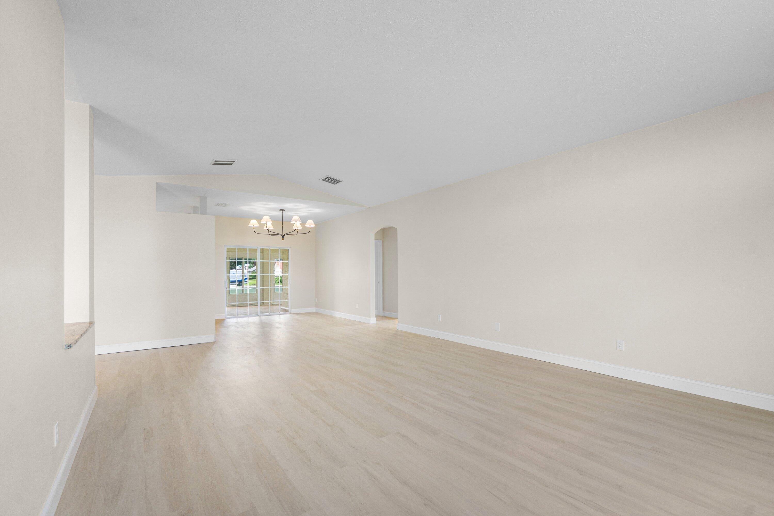 6807 Shelley Terrace Port St. Lucie, FL 34952 - Photo 6 of 34 a view of an empty room with wooden floor and a window
