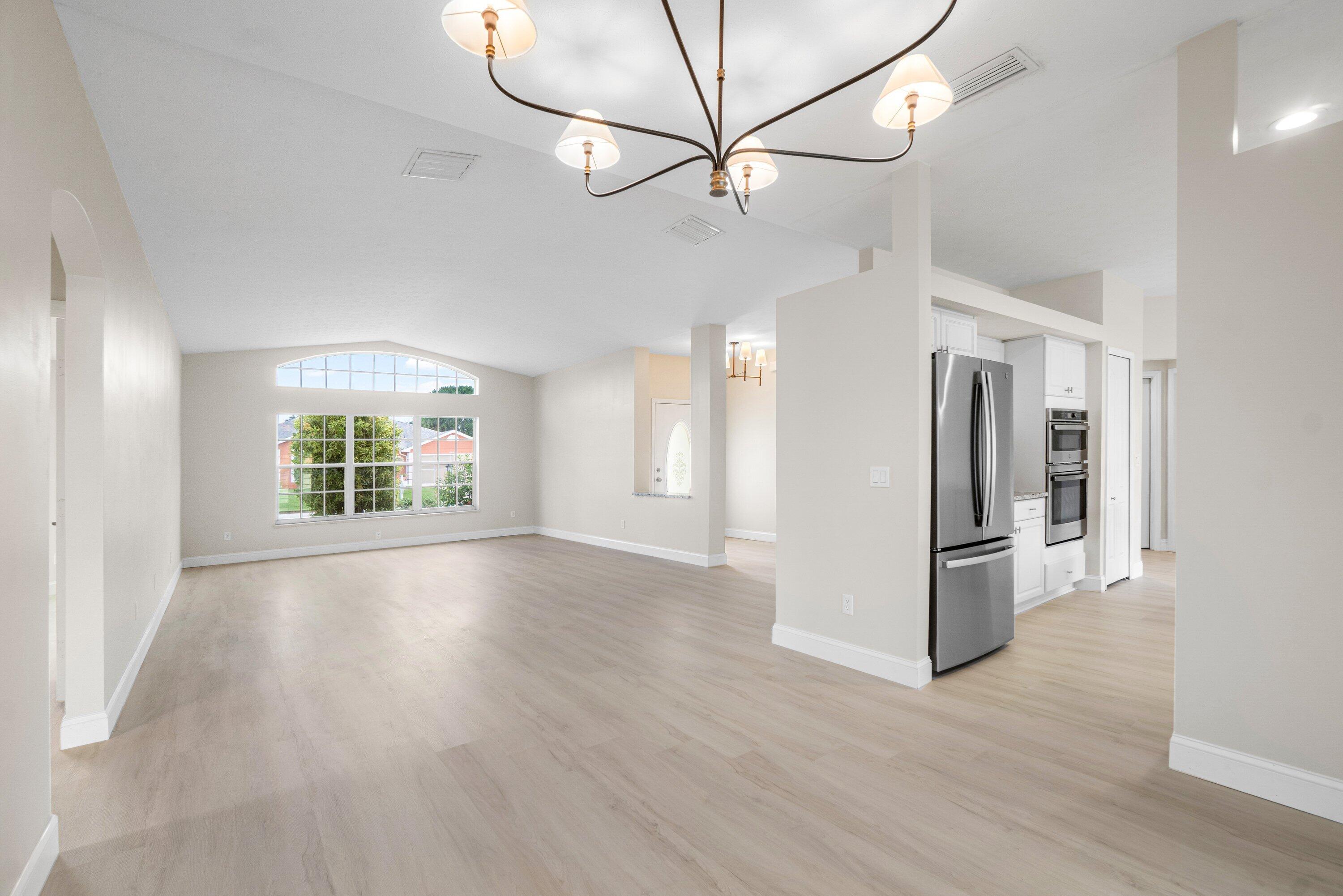 6807 Shelley Terrace Port St. Lucie, FL 34952 - Photo 7 of 34 a view of a livingroom with wooden floor a ceiling fan and windows