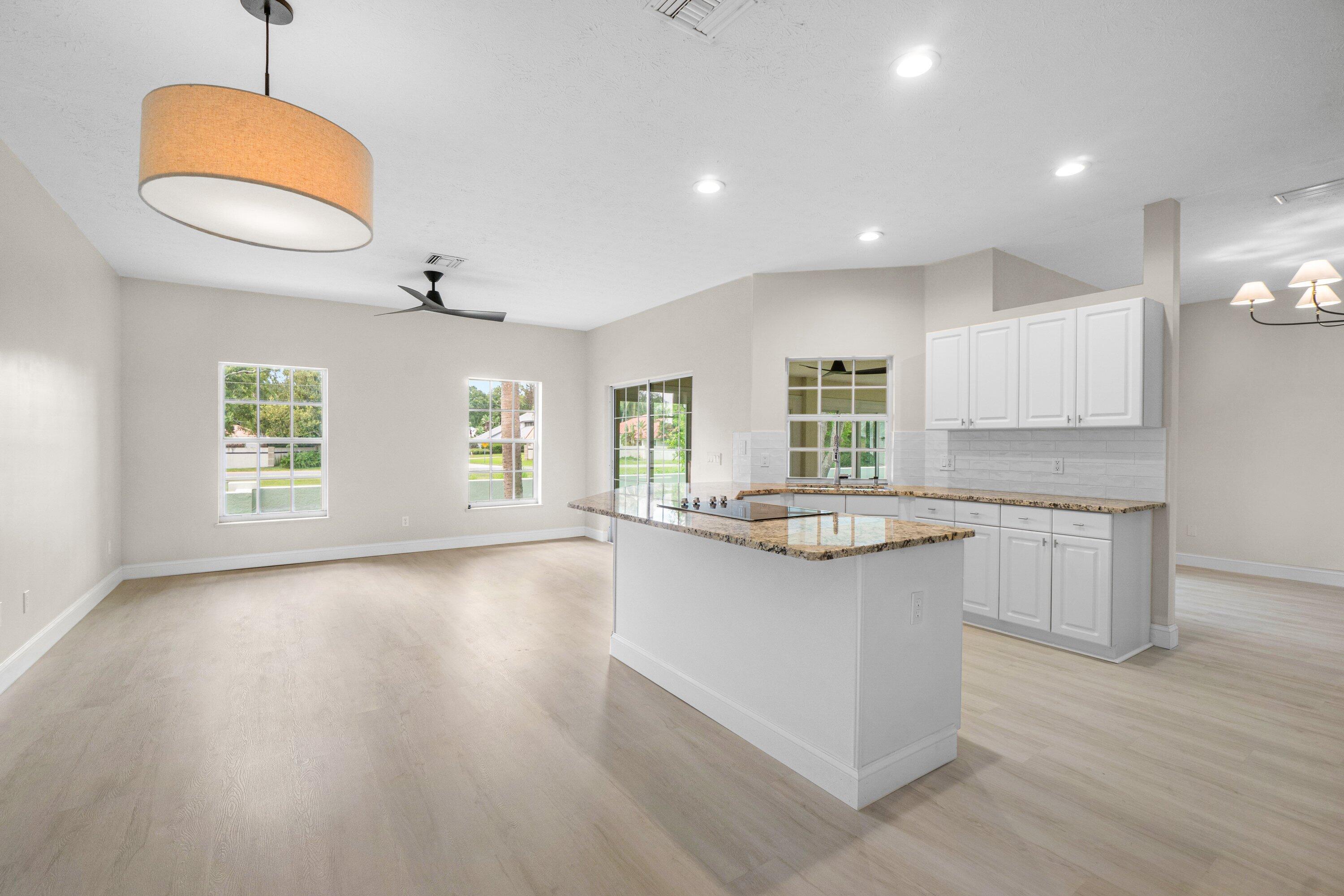 6807 Shelley Terrace Port St. Lucie, FL 34952 - Photo 8 of 34 a kitchen with granite countertop a stove a sink and a wooden floors