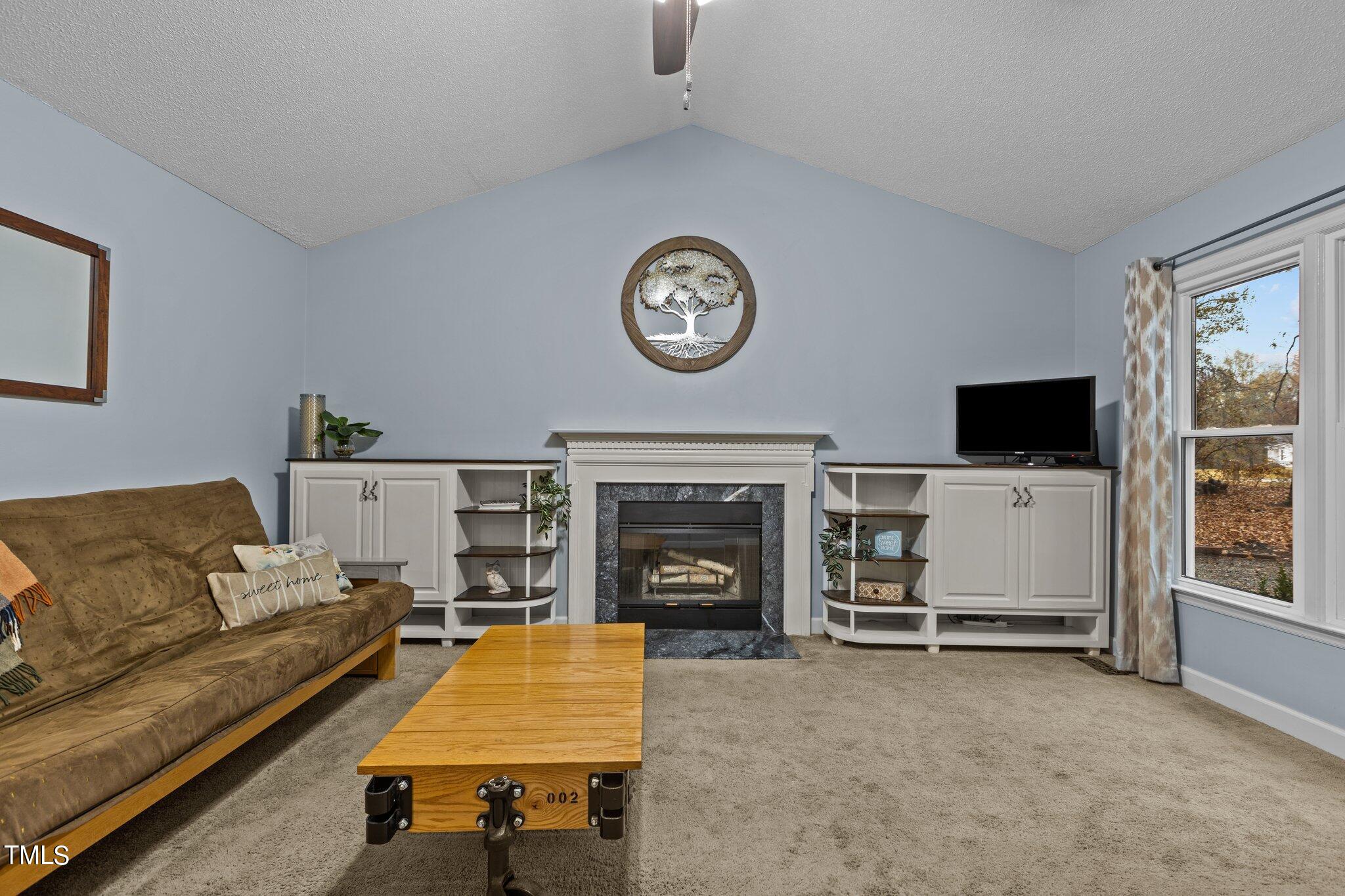 4200 Rockside Hills Drive Raleigh, NC 27603 - Photo 8 of 32 a living room with furniture a clock and a flat screen tv