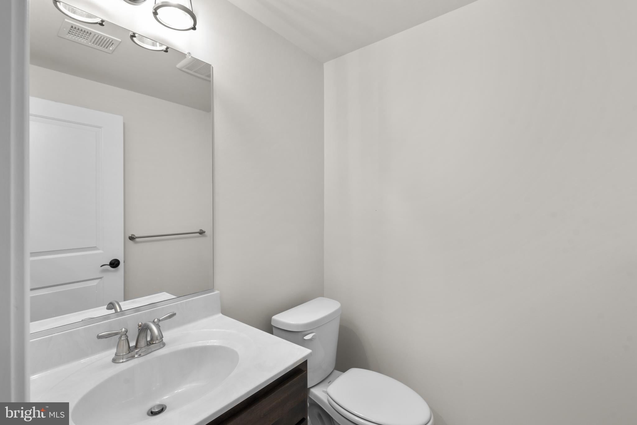 14628 Old Hanover Road, Unit REGINA Reisterstown, MD 21136 - Photo 56 of 67 a bathroom with a sink mirror and toilet