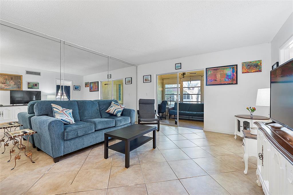 5621 Southwest 2nd Court, Unit 201 Margate, FL 33068 - Photo 2 of 17 a living room with furniture and a flat screen tv