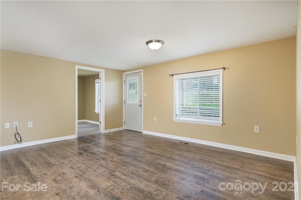 1373 Coopers Gap Road Mill Spring, NC 28756 - Photo 23 of 44 a view of an empty room with wooden floor and a window