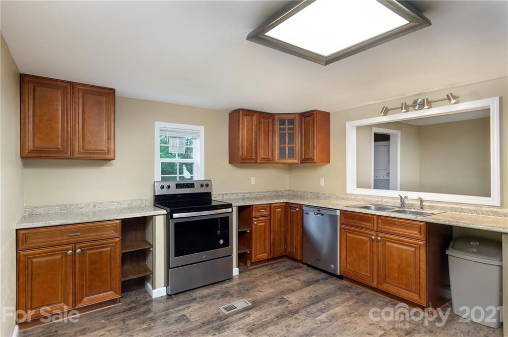 1373 Coopers Gap Road Mill Spring, NC 28756 - Photo 9 of 44 a kitchen with stainless steel appliances granite countertop a stove sink and cabinets