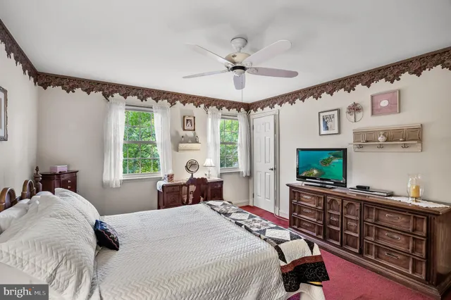 a bedroom with a bed window and a flat screen tv