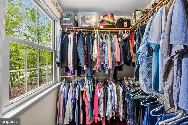 a view of walk in closet with clothes