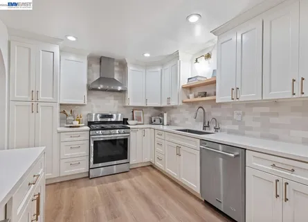 a kitchen with stainless steel appliances granite countertop a stove sink and cabinets