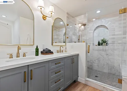 a bathroom with a double vanity sink mirror and shower