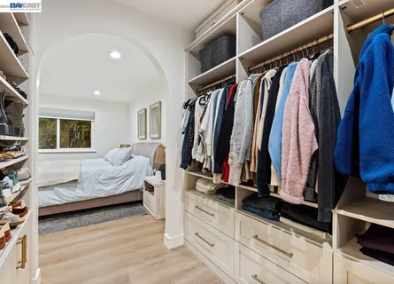 a view of walk in closet with clothes and shoes