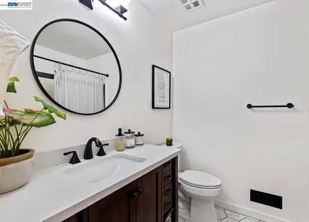 a bathroom with a sink a toilet and a mirror