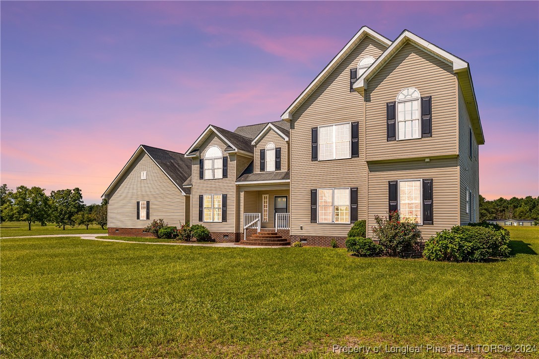 a front view of a house with a yard and trees