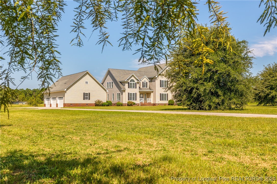 1591 Shannon Road Lumberton, NC 28360 - Photo 11 of 12 a view of a house with a big yard and large trees