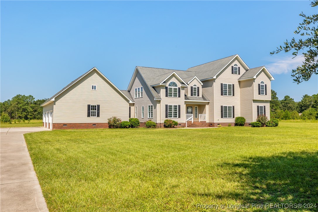 1591 Shannon Road Lumberton, NC 28360 - Photo 3 of 12 a view of a big house with a big yard and large trees