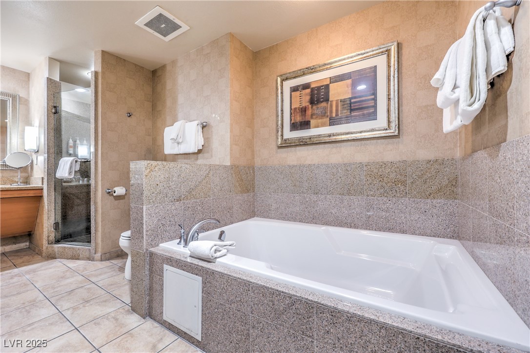 211 East Flamingo Road, Unit 1505 Las Vegas, NV 89169 - Photo 22 of 45 Full bathroom featuring light tile patterned flooring, a stall shower, vanity, a bath, and tile walls