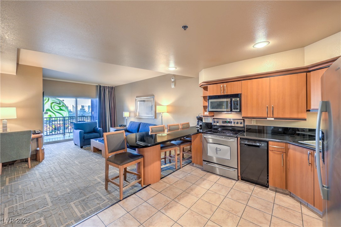 211 East Flamingo Road, Unit 1505 Las Vegas, NV 89169 - Photo 45 of 45 Kitchen featuring open floor plan, brown cabinetry, appliances with stainless steel finishes, and a breakfast bar