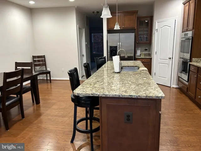 a kitchen with granite countertop kitchen island stainless steel appliances a dining table chairs and granite counter tops