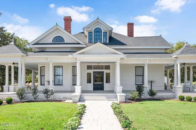 a front view of a house with garden and porch