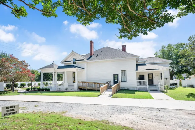 a white vase with flowers sitting on a table