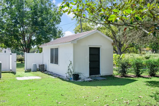 a view of a hallway with wooden floor and a chandelier