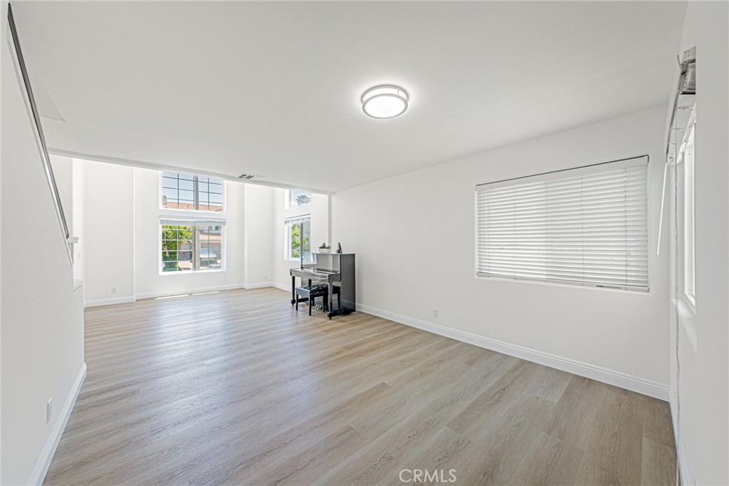 25533 Longfellow Place Stevenson Ranch, CA 91381 - Photo 6 of 47 an empty room with wooden floor and windows