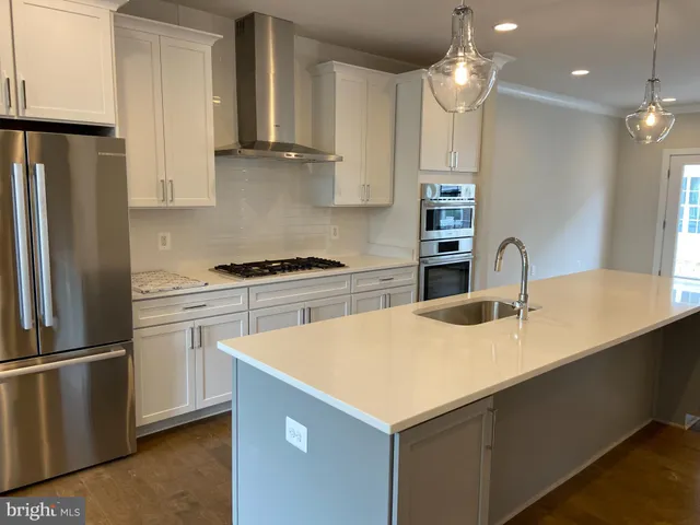 a kitchen with a refrigerator a sink and cabinets