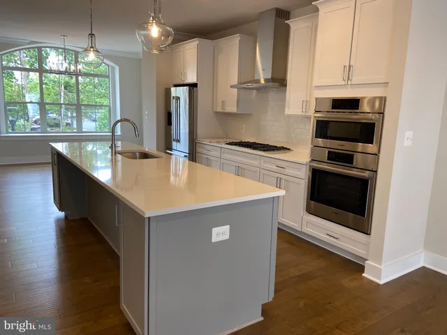 a kitchen with kitchen island granite countertop a stove and a sink