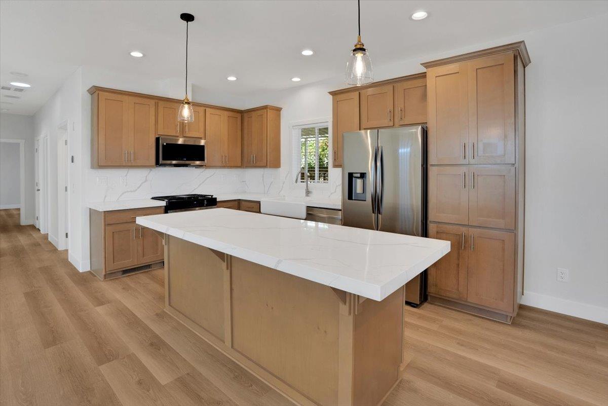 144 Holm Road, Unit 55 Watsonville, CA 95076 - Photo 9 of 24 a kitchen with kitchen island a sink stainless steel appliances and refrigerator