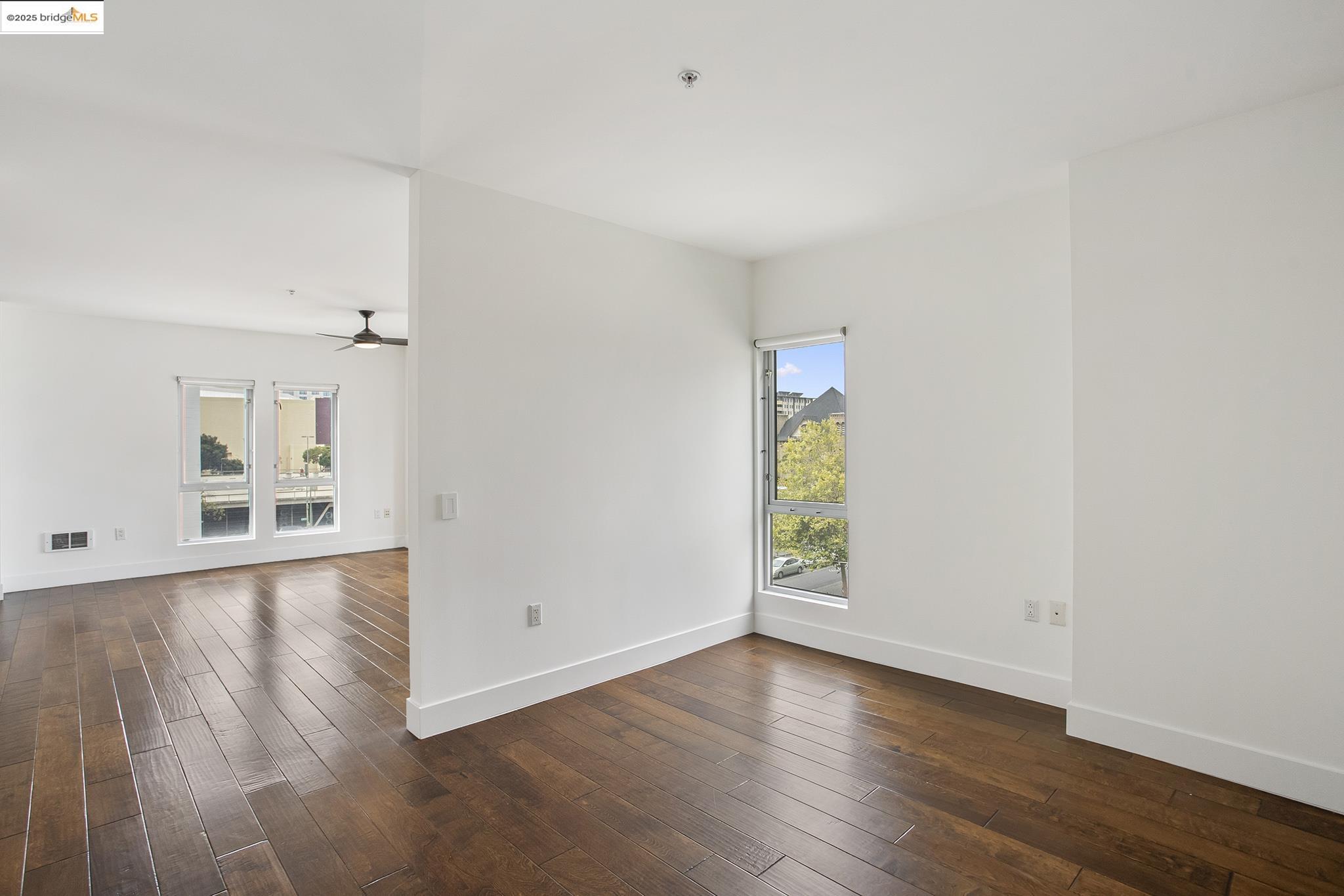 438 West Grand Avenue, Unit 401 Oakland, CA 94612 - Photo 12 of 30 an empty room with wooden floor and windows