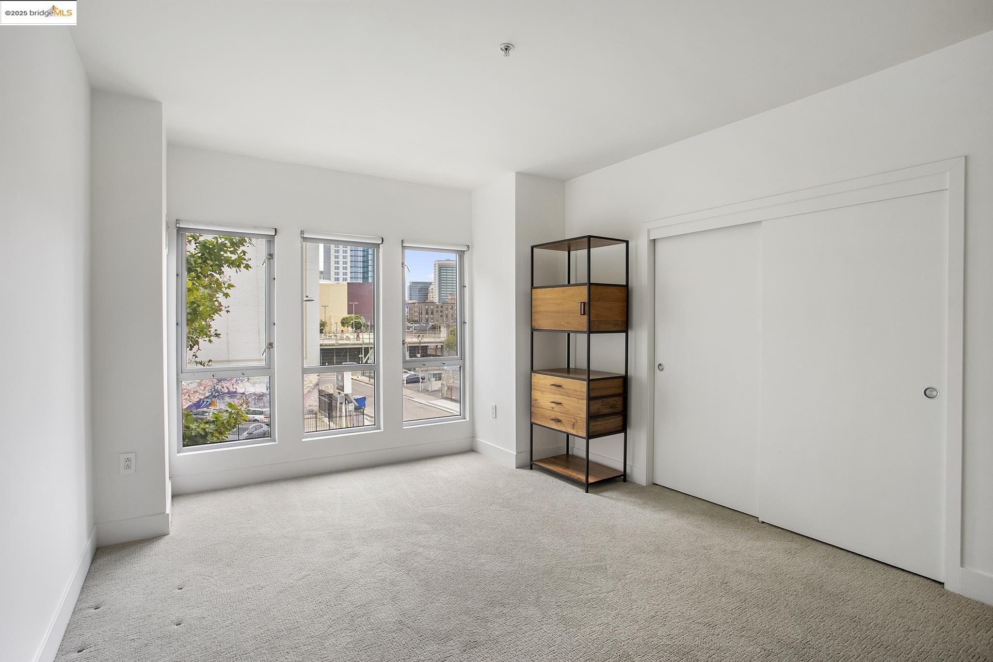 438 West Grand Avenue, Unit 401 Oakland, CA 94612 - Photo 23 of 30 an empty room with windows and closet
