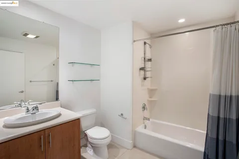 a view of an empty room with cabinet and mirrors