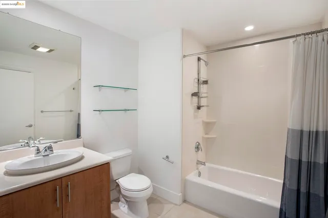 a view of an empty room with cabinet and mirrors