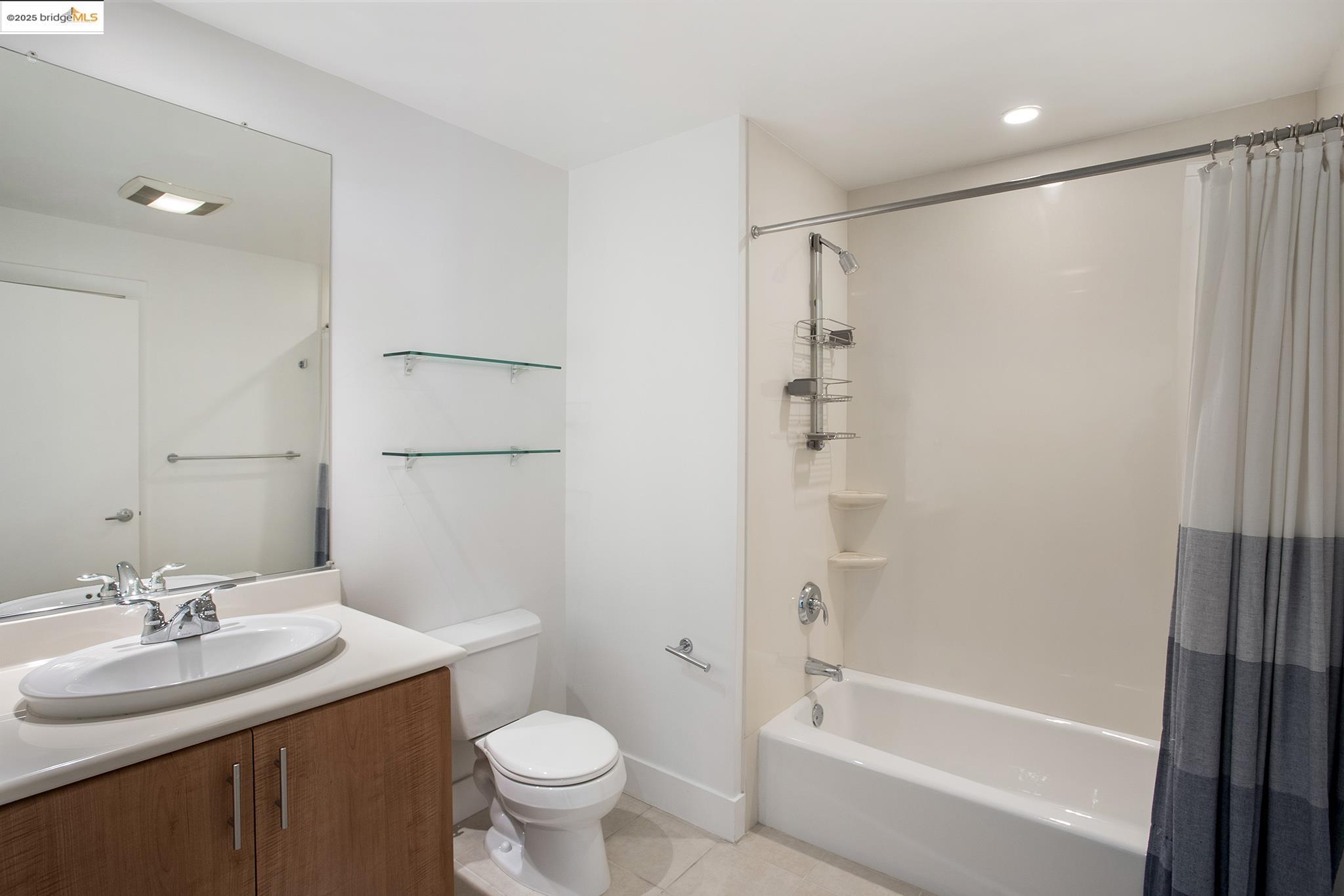 438 West Grand Avenue, Unit 401 Oakland, CA 94612 - Photo 25 of 30 a bathroom with a granite countertop sink toilet and shower