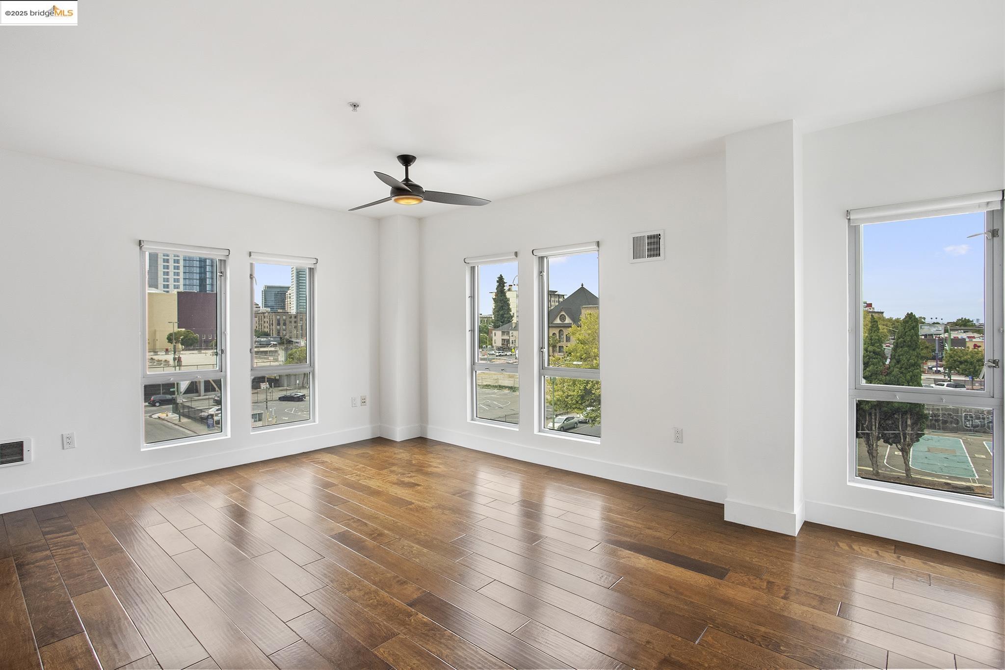 438 West Grand Avenue, Unit 401 Oakland, CA 94612 - Photo 7 of 30 a view of an empty room with a window and wooden floor