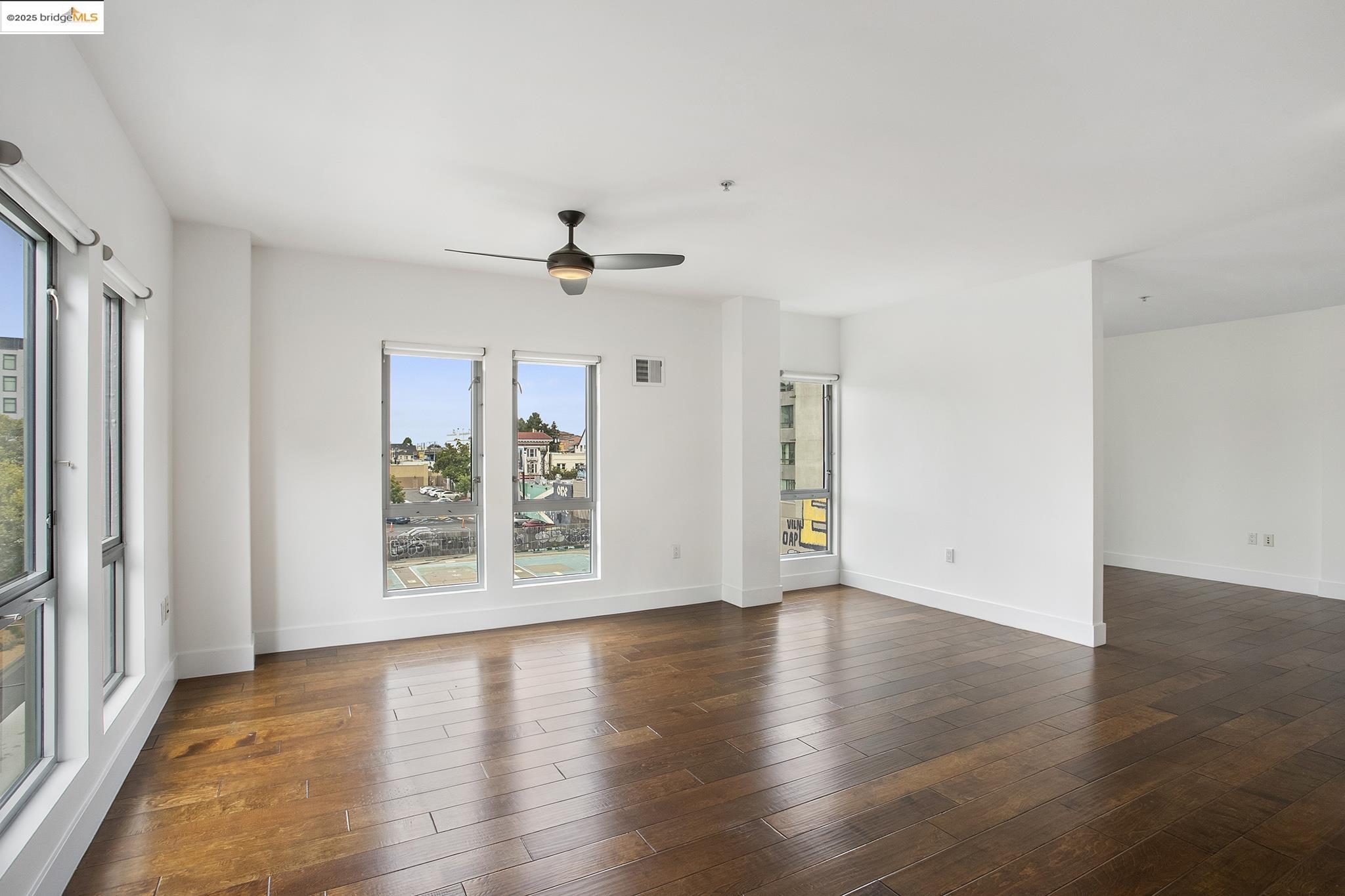 438 West Grand Avenue, Unit 401 Oakland, CA 94612 - Photo 8 of 30 an empty room with wooden floor and windows