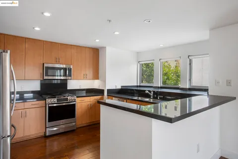 a kitchen with stainless steel appliances granite countertop a stove a sink and a microwave