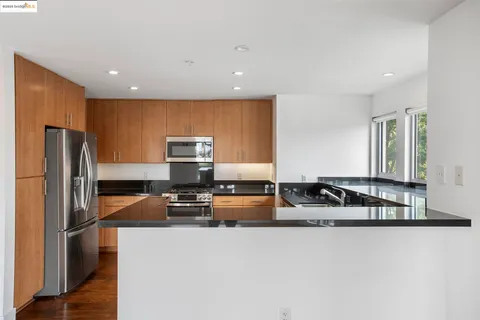 a kitchen with stainless steel appliances granite countertop a refrigerator and a sink