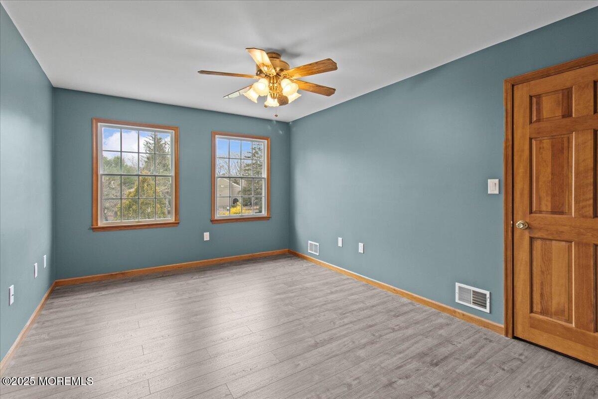 73 Porter Road Howell, NJ 07731 - Photo 64 of 65 an empty room with wooden floor chandelier fan and windows