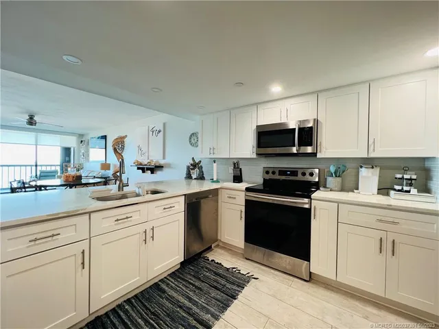 a living room with couches and a potted plant on the wall