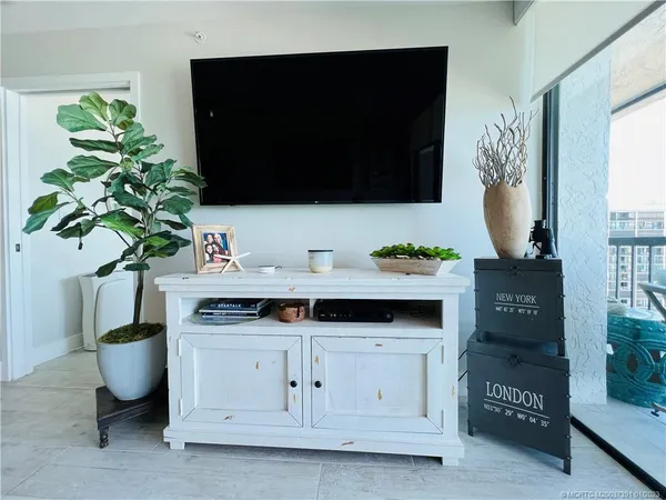 a bedroom with a balcony a bed and a flat screen tv