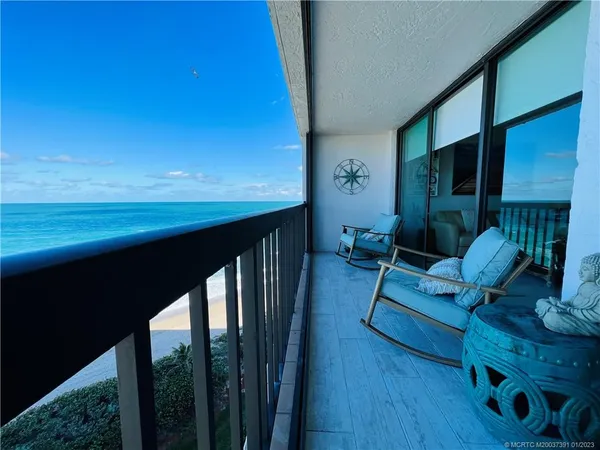 a living room with furniture a ceiling fan and a large window