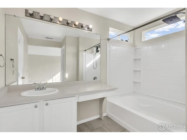 a bathroom with a sink double vanity mirror and a bathtub