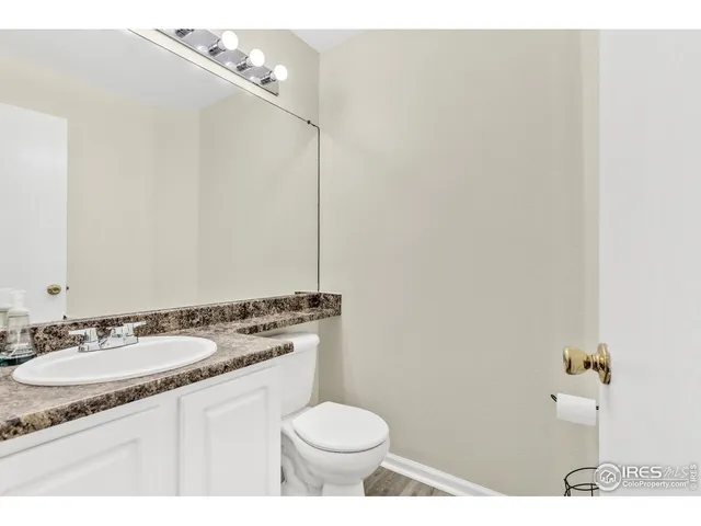 a bathroom with a granite countertop sink a toilet and a mirror