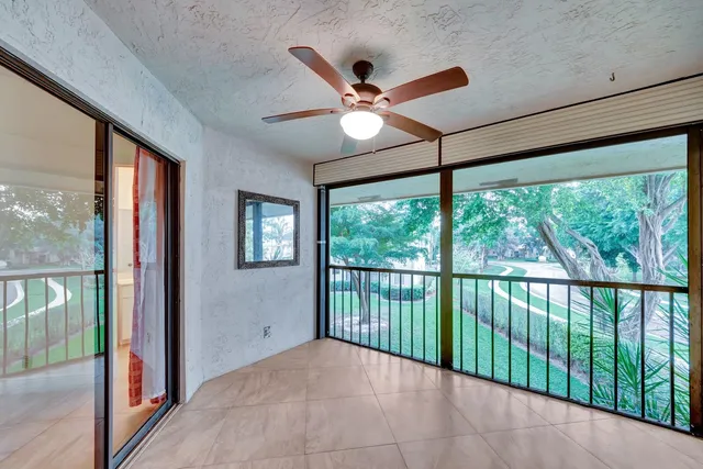 a view of an empty room with a window and a ceiling fan