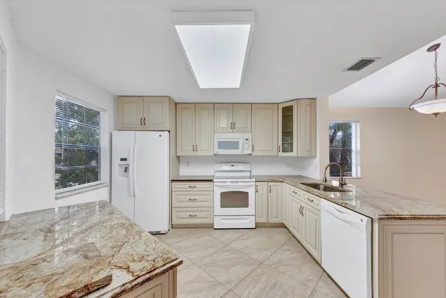 a kitchen with stainless steel appliances granite countertop a sink stove and cabinets