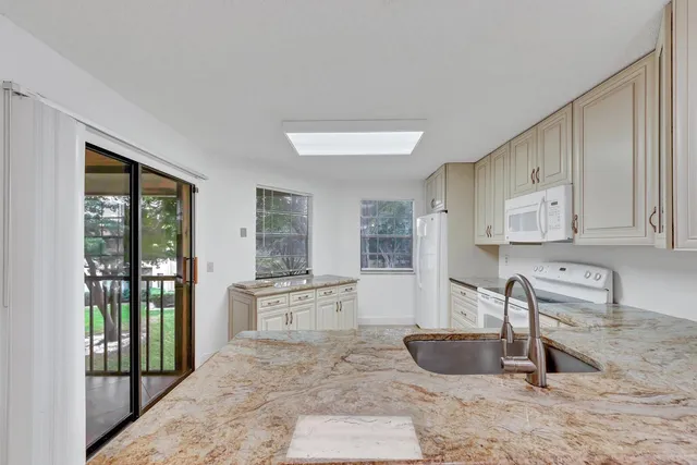 a kitchen with granite countertop a stove and a sink