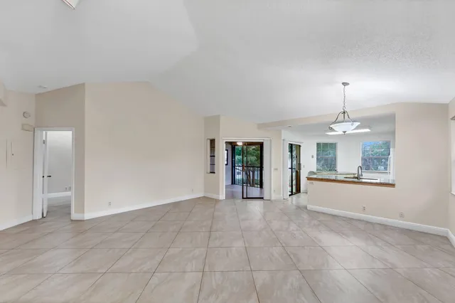 an empty room with windows and chandelier