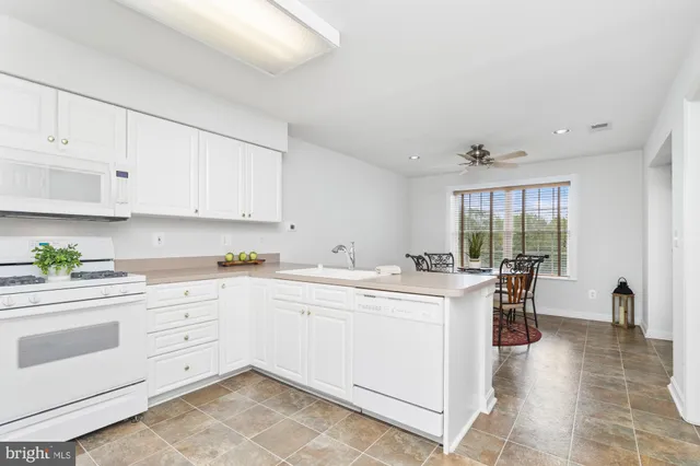 a kitchen with a refrigerator a stove and white cabinets